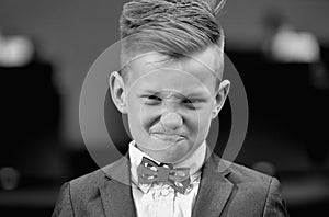 Fashion kid boy in suit and bow tie. Lifestyle portrait of funny kid outdoors. Summer kids outdoor portrait. Close up