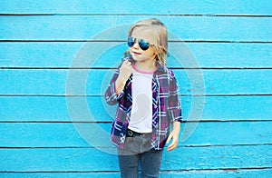 Fashion kid in city, stylish child wearing a sunglasses