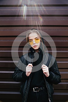 Fashion kid concept - stylish girl child wearing black casual clothes and sunglasses posing summer in the city