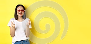 Fashion and lifestyle concept. Attractive asian woman in stylish sunglasses, showing finger hearts and smiling happy at