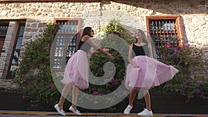 Fashion lifestyle two young women in tulle skirt funnily dancing