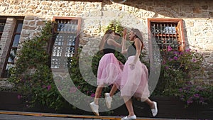 Fashion lifestyle two young women in tulle skirt funnily meet each other