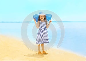 Fashion little girl in a striped dress and hat