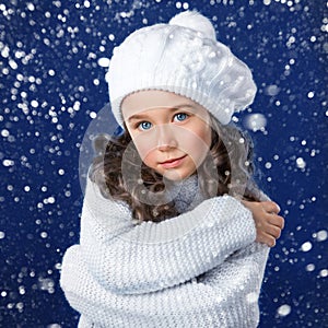 Fashion little girl in winter clothing on snow background