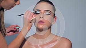 Fashion make-up fot young sexy woman. Close up visage, cosmetic, mascara. Makeup artist applying foundation skin