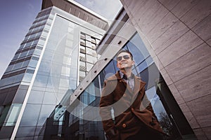 Fashion man in front of a glass building