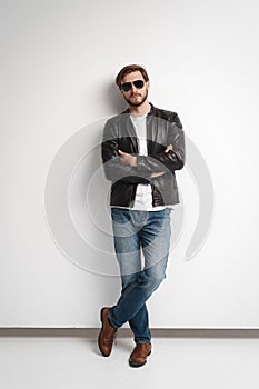 Fashion man, Handsome beauty male model portrait wear sunglasses and leather jacket, young guy over white background