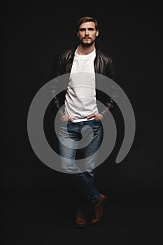 Fashion man, Handsome serious beauty male model portrait wear leather jacket, young guy over black background.