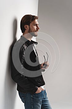 Fashion man, Handsome serious beauty male model portrait wear leather jacket, young guy over white background.