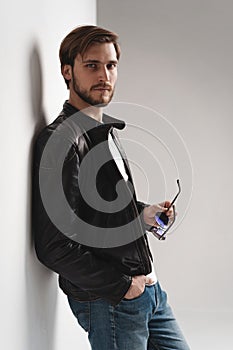 Fashion man, Handsome serious beauty male model portrait wear leather jacket, young guy over white background.