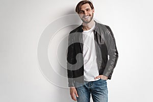 Fashion man, Handsome serious beauty male model portrait wear leather jacket, young guy over white background.