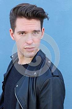 Fashion man, Handsome serious beauty male model portrait wearing leather jacket, young guy over blue background