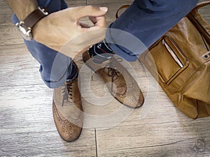 Fashion man legs in indigo navy blue pants, navy anchor socks, leather shoes and leather tote bag