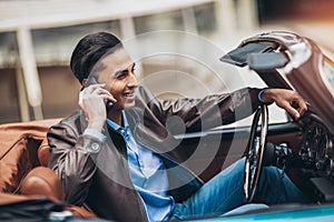 Fashion man sitting in luxury retro cabriolet car