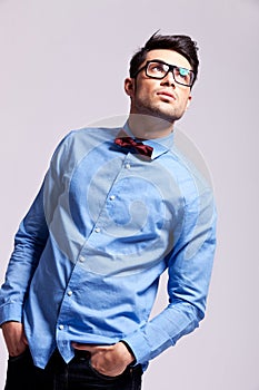 Fashion man wearing bow tie and glasses looks up