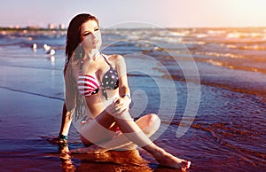 Fashion model in American flag bikini, swimwear relax on the beach. Wallpaper