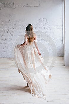 Fashion model in a beautiful beige flowing dress.