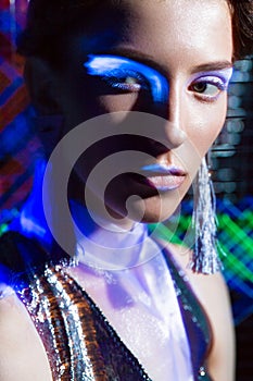 Fashion model beautiful girl in fashionable clothes in ultraviolet light, showing different poses. Beauty body and face.