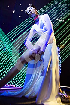 Fashion model beautiful girl in fashionable clothes in ultraviolet light, showing different poses. Beauty body and face.