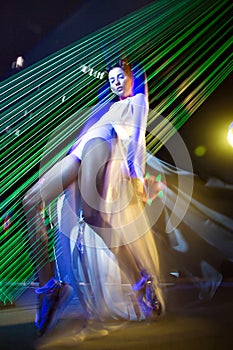 Fashion model beautiful girl in fashionable clothes in ultraviolet light, showing different poses. Beauty body and face.