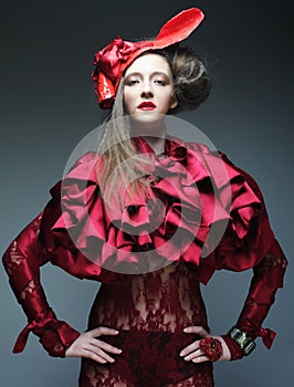 Fashion model in bright red costume and red hat