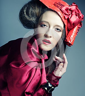 Fashion model in bright red costume and red hat