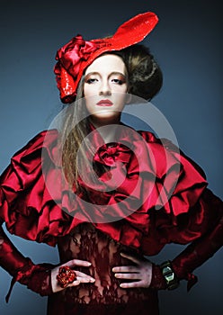 Fashion model in bright red costume and red hat