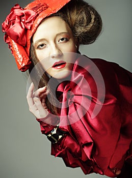 Fashion model in bright red costume and red hat