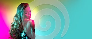 Fashion model brunette woman in colorful bright neon lights posing in studio. Beautiful girl, trendy art design make