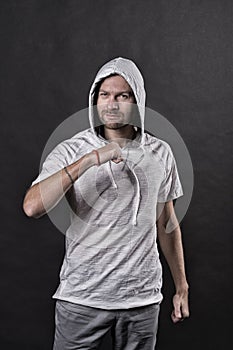 Fashion model with clenched fist gesture. Bearded man in casual sweatshirt. Man in hood in hoodie tshirt. Active