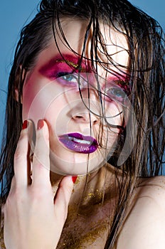 Fashion model with colorful make-up. Golden bright sparkles
