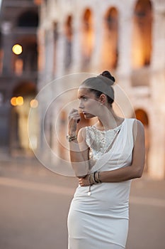 Fashion model with coloseum in background. Rome, Italy