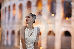 Fashion model with coloseum in the background. Rome, Italy