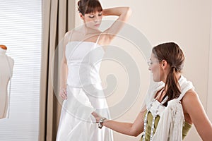 Fashion model fitting wedding dress by designer