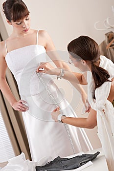 Fashion model fitting white dress by designer photo