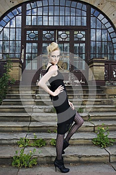 Fashion model in front of and old house