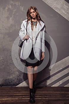 Fashion Model girl full length portrait in the white coat. High