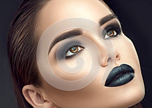 Fashion model girl portrait with trendy gothic black makeup. Young woman with black lipstick, dark smokey eyes