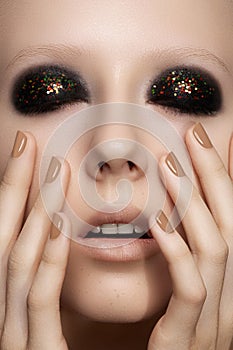 Fashion model with glitter make-up, shiny manicure