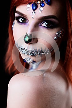 Fashion model with halloween skull makeup with glitter and rhinestones