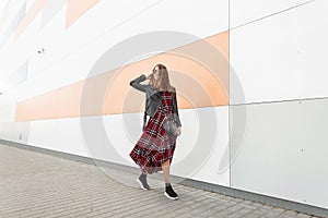 Fashion model happy urban hipster in dark sunglasses with smile in fashionable youth red-black outfit and stylish sneakers travel