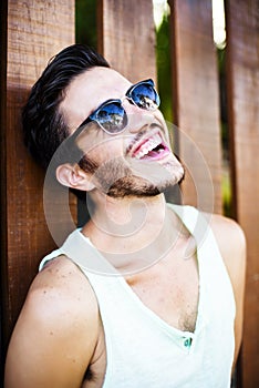 Fashion model leaning agains a wooden fence