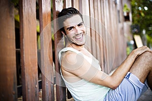 Fashion model leaning agains a wooden fence