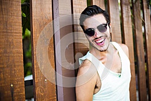 Fashion model leaning againsT a wooden fence