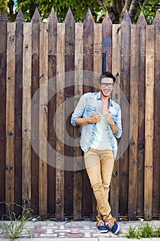 Fashion model leaning against a wooden wall a wooden wall