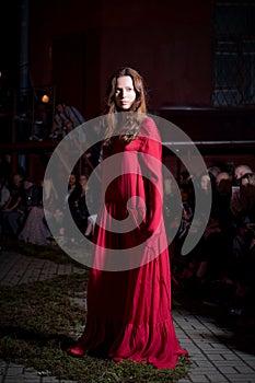 Fashion model in long wide designers dress at night show