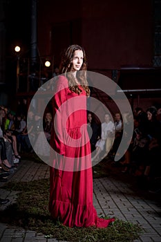 Fashion model in long wide designers dress at night show