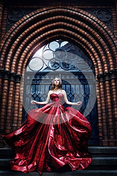 Fashion Model near Medieval Castle Gate Door, Woman Beauty Glamour Portrait in Elegant Red Dress