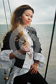 Fashion model portrait against sea landscape dressed in black leather jacket