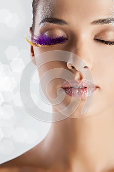 Fashion model portrait with false eyelashes purple eye lash abstract makeup look